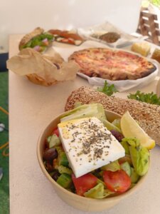 ברטה עגלת קפה קרית טבעון תמונה של סלט פיצה וכריכים על שולחן